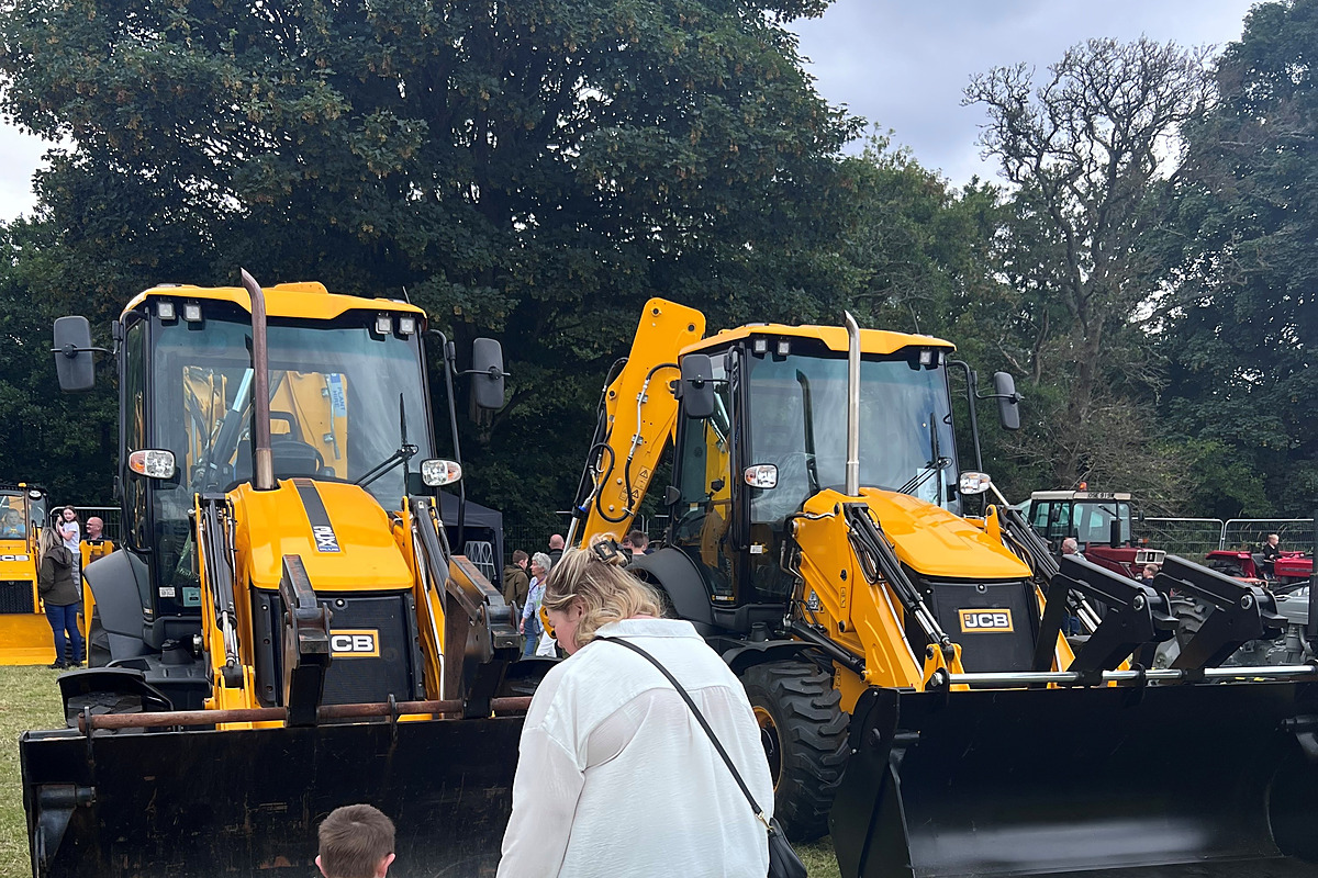 A young boy points towards a line of excavators and vintage tractors at the Nairn Show.